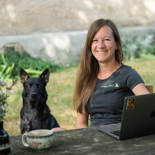 Emotionen im Unterricht – wie Lehrkräfte souverän bleiben, klar kommunizieren und innere Stärke entwickeln 16 Lehrkraft arbeitet entspannt im Garten am Laptop, während ein Hund daneben sitzt – ein Moment von Selbstfürsorge und Balance.